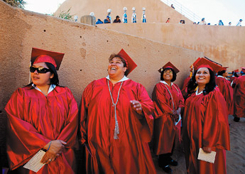 E. Michelle Burrola, center, waves at her family along with Roxanne Chimonie and Shiela Aragon prior to graduation ceremonies for University of New Mexico-Gallup graduation at Red Rock State Park Thursday. About 275 students graduated.