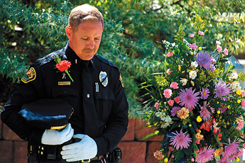 Grants Police Lieutenant Corey Allen bows his head during the reading of the Police Officer's Prayer during the Law Enforcement Memorial Ceremony in Grants Friday.