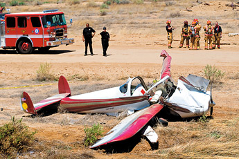 Gallup Police and Fire Department members gather at the scene of a plane wreck near Allison Road Saturday.