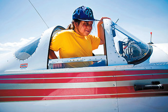 Tiffani-Rae Briggs climbs out of the cockpit of a Ercoupe airplane after taking a ride during the Rocky View Fly In at the Gallup Airport Saturday. Several small plane pilots volunteered their time to give free plane rides to kids. — © 2009 Gallup Independent / Cable Hoover