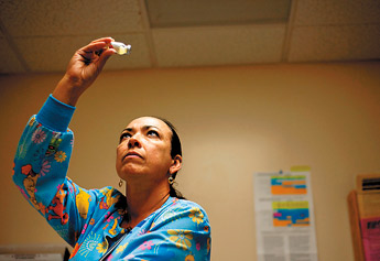 Ada Nieves Nieves RN checks a bottle before filling a syringe and giving it to a patient at Fort Defiance Indian Hospital on Tuesday. — © 2009 Gallup Independent / Brian Leddy 