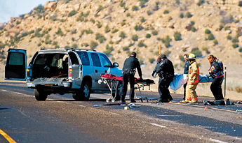Police and fire officials carry the body of a man to a Cope Memorial Chapel vehicle on Interstate 40 in this March 30 file photo. James Gaffer, 46, was killed when his eastbound traveling vehicle collided head on with a van traveling west. — © 2009 Gallup Independent / Brian Leddy 