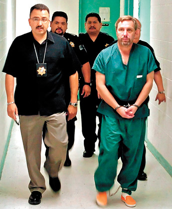 Steve Coleman is escorted by police and corrections officers into the McKinley County Courthouse in this July 21, 2006, file photo. — © 2009 Gallup Independent / Staff Photo