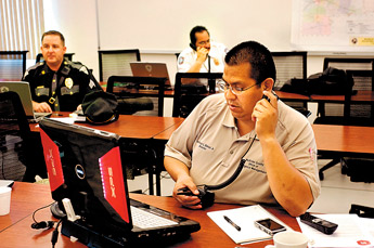 Anthony Dimas, Director of McKinley County Emergency Management , works with other representatives for law enforcement at the Gallup Emergency Operations Management Center responding to a communications black-out. — © 2009 Gallup Independent / Adron Gardner 