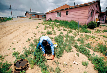 A City of Gallup collection field representative shuts of the water to a duplex in Mesa Avenue on June 2. The city has been aggressively shutting off past dues accounts in an effort to keep up with collections. — © 2009 Gallup Independent / Brian Leddy 