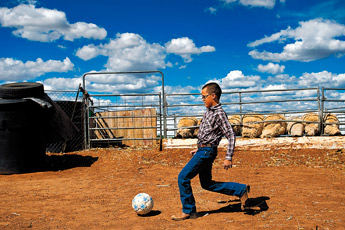 Nathaniel Cruz plays with a soccer ball after finishing his chores on his family's property near Grants, Wednesday. Cruz and his siblings are preparing several animals for competition in this year's Bi-County Fair. — © 2009 Gallup Independent / Cable Hoover 