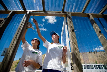Regina Timmes and Rachel Pool, both with St. Margaret Mary Catholic Church in Winter Park, Fla. paint the greenhouse at St. Mary's Mission in Tohatchi on Thursday. With the addition of solar panels and a new greenhouse, the mission is trying to lighten it's carbon footprint. — © 2009 Gallup Independent / Brian Leddy