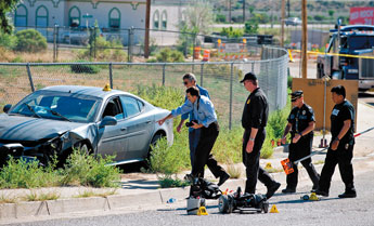 Investigators with Gallup Police Department and New Mexico State Police work a scene on Aztec Avenue on Thursday morning. An allegedly intoxicated male driver struck two pedestrians in wheelchairs as they motored down the road on Wednesday at 9 p.m. Ronald Skolte, 52, died at the scene while Tina Mulliner, 41, is in Albuquerque in satisfactory condition. — © 2009 Gallup Independent / Brian Leddy 