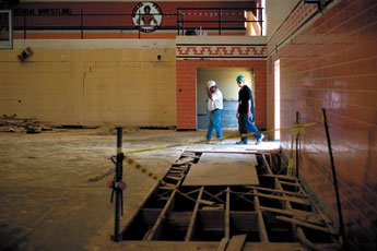 Construction workers walk through what's left of the Miyamura High School Gymnasium Friday. Renovation of the gym and construction of new facilities is scheduled to be finished in August of 2010. — © 2009 Gallup Independent / Cable Hoover