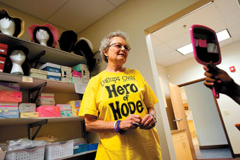 Beverly Crowe helps a cancer patient with fit her wig on Thursday at the New Mexico Cancer Center. Crowe, herself a cancer survivor, was named a Hero of Hope by the American Cancer Society.— © 2009 Gallup Independent / Brian Leddy 