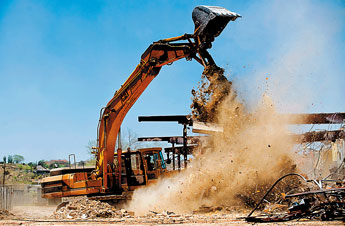 A crane moves debris at the Miyamura high School on Wednesday. — © 2009 Gallup Independent / Brian Leddy 