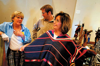 Rep Sandra Jeff of District 5 tries on the best of show piece, a woven silk poncho at Red Rock State Park on Monday. State senators and representatives were in town to took a tour of entries in the Gallup Inter-Tribal Ceremonial Art Show .— © 2009 Gallup Independent / Brian Leddy