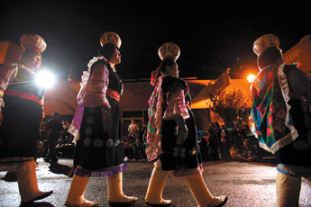 A line of Zuni Olla Maidens march through a light rain during the 88th Inter-Tribal Indian Ceremonial night parade in downtown Gallup Thursday. — © 2009 Gallup Independent / Cable Hoover 