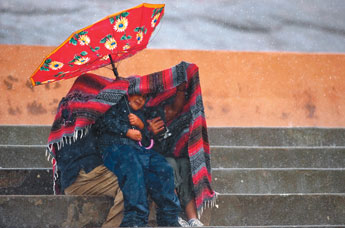 Shawn Thompson and his family try to endure the weather as they watch the rodeo at Inter-Tribal Indian Ceremonial at Red Rock Park Friday. — © 2009 Gallup Independent / Cable Hoover