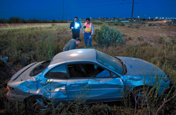 Investigators examine the damaged car of a suspect in a double fatality on New Mexico Highway 264 in Yatahey on Friday. — © 2009 Gallup Independent / Adron Gardner 