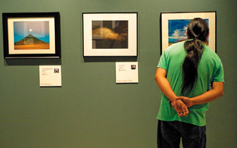 David Begay looks at the finer details of "Summer Storm" by photographer Cletus Shirley, part of an exhibit of Diné photographers on display at the Navajo Nation Museum in Window Rock. — © 2009 Gallup Independent / Adron Gardner