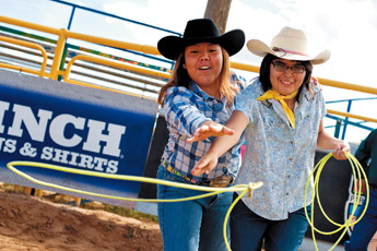 Amber Dawn shows Samantha Cosen how to rope during Friday's Exceptional Children's Rodeo at the Navajo Nation Fair on Friday. The event is an opportunity for children with mental and physical disabilities to experience a piece of the rodeo. — © 2009 Gallup Independent / Brian Leddy 