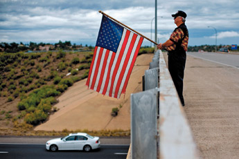 Jim Sherman of Gallup stands on Miyamura bridge on Friday morning to commemorate the anniversary of the September 11th attacks on the World Trade Center. Sherman, who has been performing the ritual since 2001, chose to stand on that particular bridge to honor Hershey Miyamura, a congressional medal of honor recipient. — © 2009 Gallup Independent / Brian Leddy 