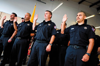 Gallup firefighters raise their hands during their swearing-in ceremony on Friday at the South Side Fire Department. Thirty-one firefighters were sworn in. — © 2009 Gallup Independent / Brian Leddy 