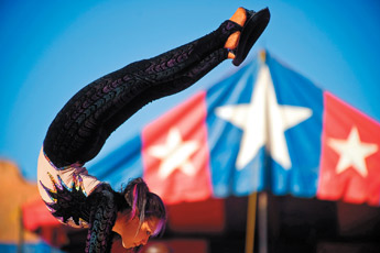Contortionist Ruby Alvarado uses her feet to place a hat on her head during her performance with the Jordan World Circus at Red Rock Park Thursday. — © 2009 Gallup Independent / Cable Hoover
