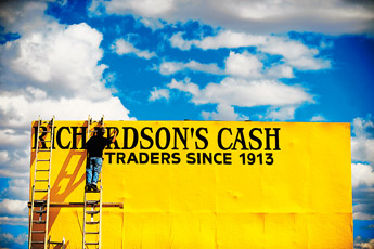 Ric Sarracino, owner of the Gallup business Signs of the Times, paints a billboard along Historic Route 66 across from Albertson's on Tuesday afternoon. The lettering on the sign was hand painted by Sarracino, who also paints when not working. — © 2009 Gallup Independent / Brian Leddy 