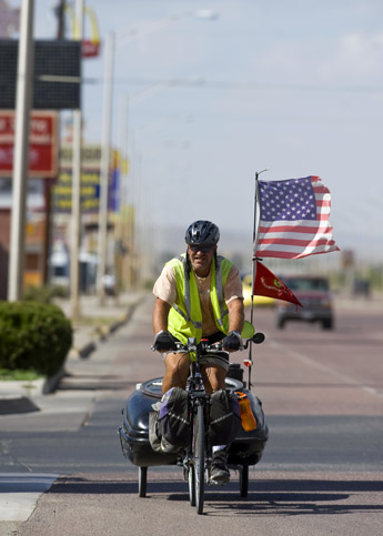 Jim Ellison of Butte, Mont. rides his bike along Historic route 66 on Wednesday morning. Butte, a Marine veteran that served in Desert Storm and has two sons there as well, has been riding his bike all over America for the past 6 years to show his support for troops in Iraq. He says he'll stop when the troops come home. — © 2009 Gallup Independent / Brian Leddy