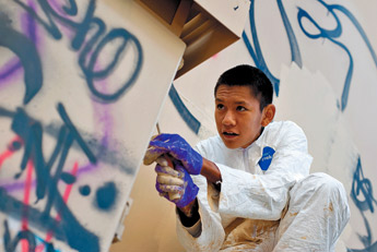Navajo Pine High School student Seth Martin paints over graffiti on a water tank in Navajo on Thursday morning. — © 2009 Gallup Independent / Brian Leddy 