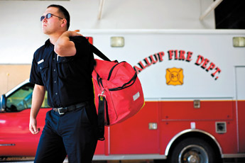 Fire fighter Vaughn Kendall carries his gear through the truck bay at the south side fire station Wednesday. — © 2009 Gallup Independent / Cable Hoover
