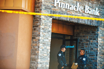 Gallup Police officers stand at the entryway of Pinnacle Bank on East Aztec Avenue on Tuesday afternoon. A bank robber made away with an undisclosed amount of cash. — © 2009 Gallup Independent / Brian Leddy 