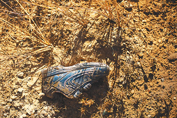 A shoe rests in the dirt near the scene of a fatal on-vehicle accident on Tuesday morning on Highway 264. The vehicle apparently ran the stop sign while heading north on County Road one, crossed Highway 264 and hit the embankment and flipped three times before coming to rest. — © 2009 Gallup Independent / Brian Leddy 
