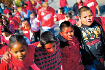 Roosevelt Elementary students Chauncey Hall, left, Chris Madrid, Shauntae Chee and Lathan Kinsel walk together during the school's Red Ribbon Week parade on Cliff Drive Thursday. About 240 students participated in the annual drug free awareness event. — © 2009 Gallup Independent / Cable Hoover