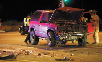 Gallup firefighters and police examine the wreckage from one of two SUV's involved in a collision at N.M. 602 and Aztec on Thursday. — © 2009 Gallup Independent / Adron Gardner 