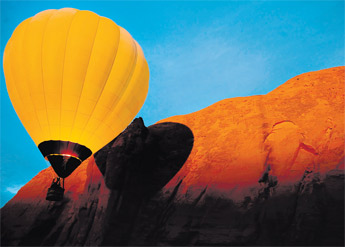 A yellow balloon casts a strong shadow across the red rock cliffs at dawn Saturday during the 29th annual Red Rock Balloon Rally in Gallup. — © 2009 Gallup Independent / Adron Gardner