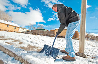 Steve Houck shovels some snow off the sidewalk adjacent to his home on Aztec in Gallup on Tuesday. — © 2009 Gallup Independent / Adron Gardner