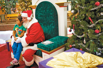 Chanti Kaamasee, 4, and Santa pose for a holiday photo at the Rio West Mall on Wednesday. — © 2009 Gallup Independent / Adron Gardner 