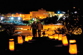 Sightseers walk the luminaria path at First Baptist Church to view the Living Nativity on Thursday evening. — © 2009 Gallup Independent / Cable Hoover