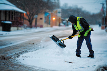 Gallup city employee Peter Benally shovels snow from a sidewalk in downtown on Wednesday morning. Gallup received about 2 inches of snow with more still on the way. — © 2009 Gallup Independent / Brian Leddy 