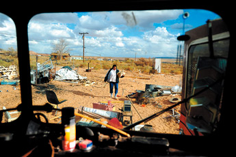 Ula Hardy gathers wood to heat their bus as a storm approaches in Tuba City, Ariz. in November. Hardy lives in a bus with her husband after her home burned down several years ago. Hardy's home was on Bennett Freeze land so she has had trouble getting assistance to rebuild. — © 2009 Gallup Independent / Brian Leddy 
