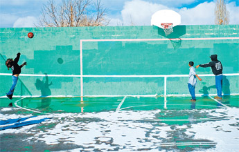 Kristen Britton, left, Justin Livingston and Derrick Smith play basketball in a small snow-free patch of court at Ford Canyon Park Wednesday in Gallup. — © 2009 Gallup Independent / Cable Hoover