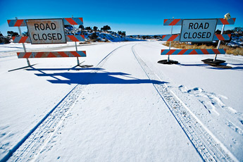 Signs mark the intersection where Mendoza Road is closed at N.M. Highway 602 Thursday in Gallup. — © 2010 Gallup Independent / Cable Hoover