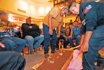 Brian Begay, right, of team Máii (coyote) from Black Rock, takes his chances on the shoes of the Naughty Boys from Gamerco for the Navajo shoe game in Window Rock on Thursday. — © 2010 Gallup Independent / Adron Gardner