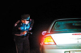 State Police officer Devin Largo makes a traffic stop on U.S. Highway 491 while on patrol with a New Years Eve DWI task force Thursday night. — © 2010 Gallup Independent / Cable Hoover