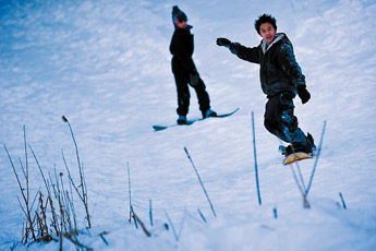 Nikki Paraguya, right and his friend JK Fiedachan practice snowboarding on a small slope near McGaffey Lake Sunday.— © 2010 Gallup Independent / Cable Hoover 
