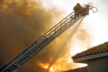 Gallup Firefighter Craig Carver aims a hose from a ladder at the roof of the Days Inn in west Gallup to help fight a fire that destroyed the hotel early Sunday morning. — © 2010 Gallup Independent / Cable Hoover 