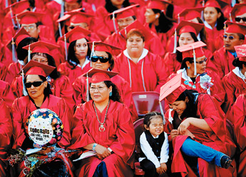 Racheal Sloan tickles her son with her tassel during commencement ceremonies for University of New Mexico-Gallup students at Red Rock State Park on Thursday.