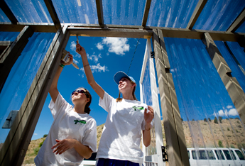 Regina Timmes and Rachel Pool, both with St. Margaret Mary Catholic Church in Winter Park, Fla. paint the greenhouse at St. Mary's Mission in Tohatchi on Thursday. With the addition of solar panels and a new greenhouse, the mission is trying to lighten it's carbon footprint. &mdash;&nbsp;&copy; 2009 Gallup Independent / Brian Leddy