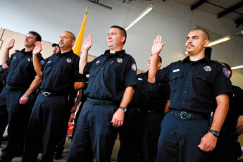 Gallup firefighters raise their hands during their swearing-in ceremony on Friday at the South Side Fire Department. Thirty-one firefighters were sworn in. &mdash;&nbsp;&copy; 2009 Gallup Independent / Brian Leddy 