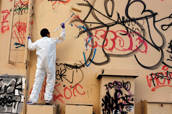 Navajo Pine High School student Jermaine Chee paints over graffiti on a water tank in Navajo on Thursday morning. About 60 students took the day to help erase some of the graffiti that litters the community. &mdash;&nbsp;&copy; 2009 Gallup Independent / Brian Leddy 