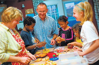 Sheila Kruis, left, and Brian Kruis, center, decorate Thanksgiving cookies with their children Amber, right, Elizabeth, Ruthann and Josiah at their home Friday. The Kruis family adopted three of the children and is in the process of adopting a fourth. &mdash;&nbsp;&copy; 2009 Gallup Independent / Cable Hoover 