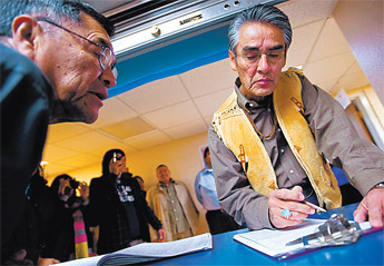 Suspended Navajo Nation President Joe Shirley, right, gets instructions from Johnny R. Thompson as he signs in for early voting at the Navajo Election Administration office in Window Rock Tuesday. &mdash;&nbsp;&copy; 2009 Gallup Independent / Cable Hoover 